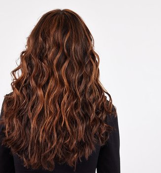 Rückansicht einer Frau mit langen gewellten braunen Haaren