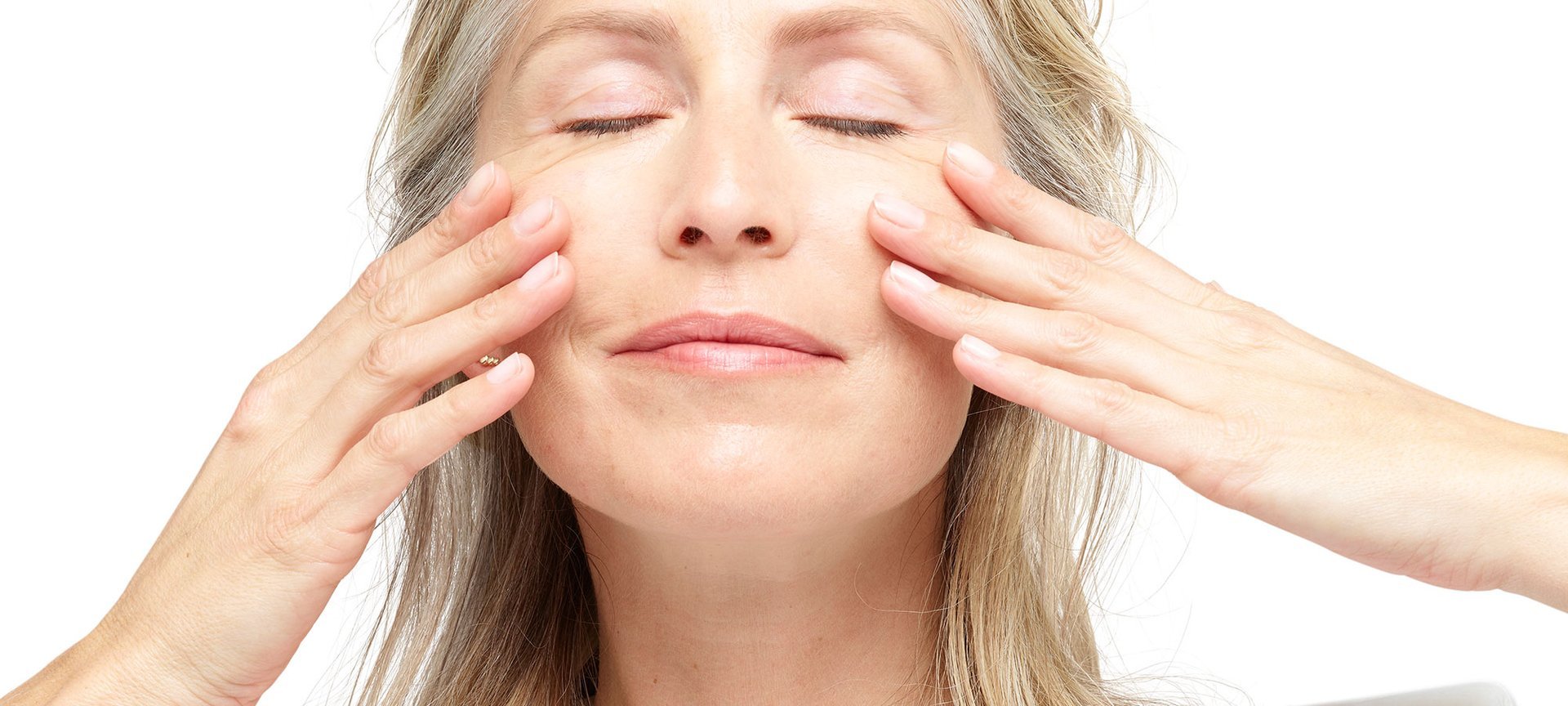 Ein Frau streicht sich geniessend mit ihren Händen über ihre Wangen