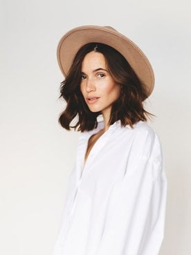 Frau mit schwarzen Haaren und Hut