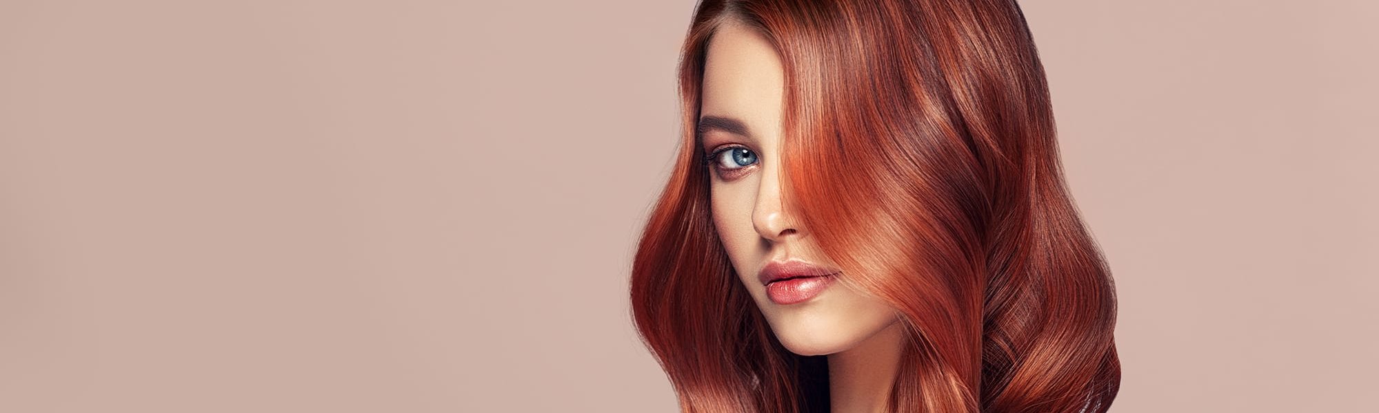 Frau mit langen gepflegten Haaren blickt in die Kamera