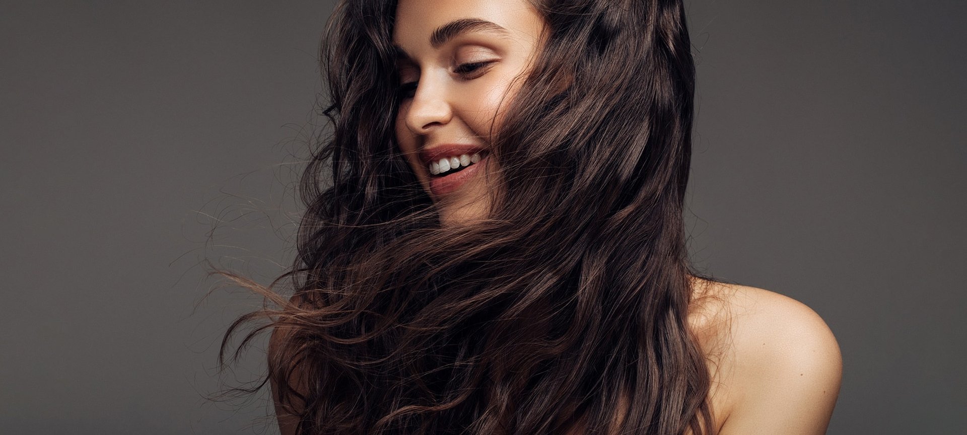 Junge Frau mit langen dunklen Haaren, lächelnd