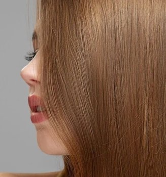 Über das Seitenprofil einer Frau fällt ihr langes Haar in der Farbe Straßenköterblond