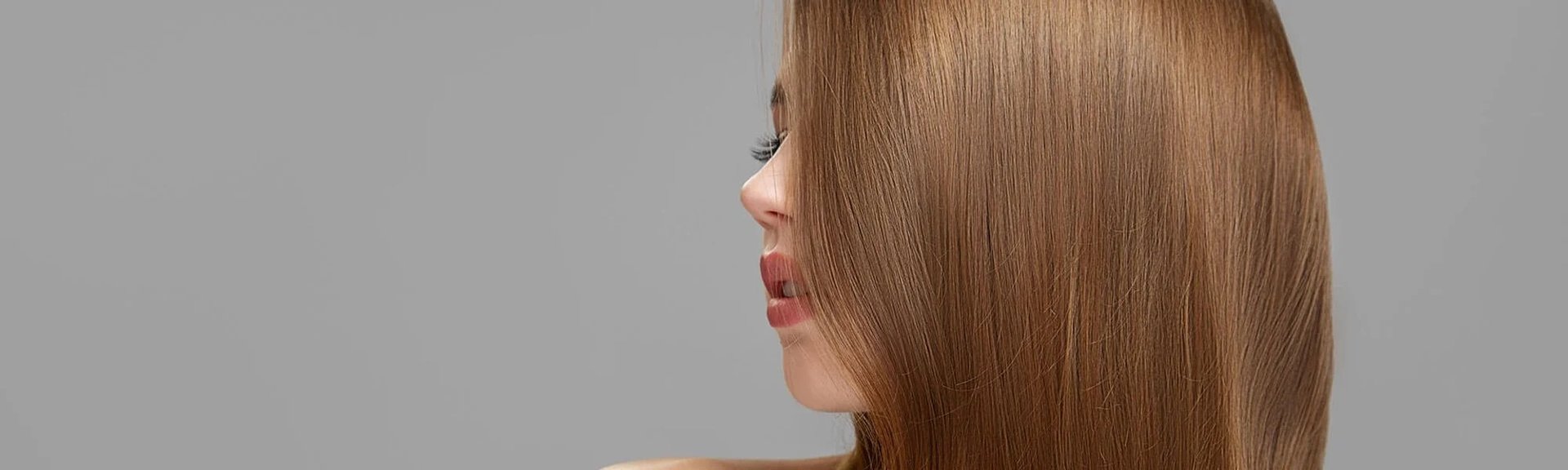 Über das Seitenprofil einer Frau fällt ihr langes Haar in der Farbe Straßenköterblond