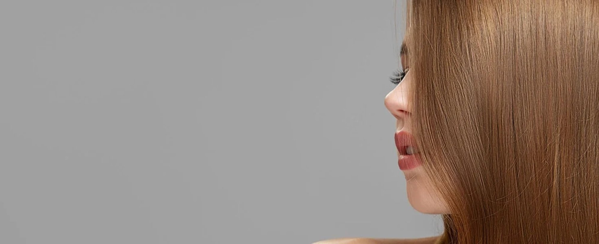 Über das Seitenprofil einer Frau fällt ihr langes Haar in der Farbe Straßenköterblond