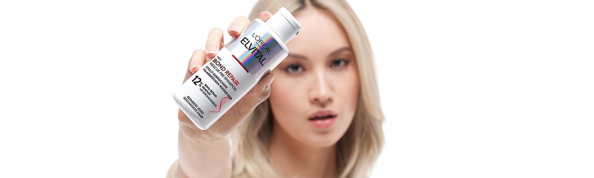 Eine Frau hält ein Elvital Bond repair in ihrer Hand