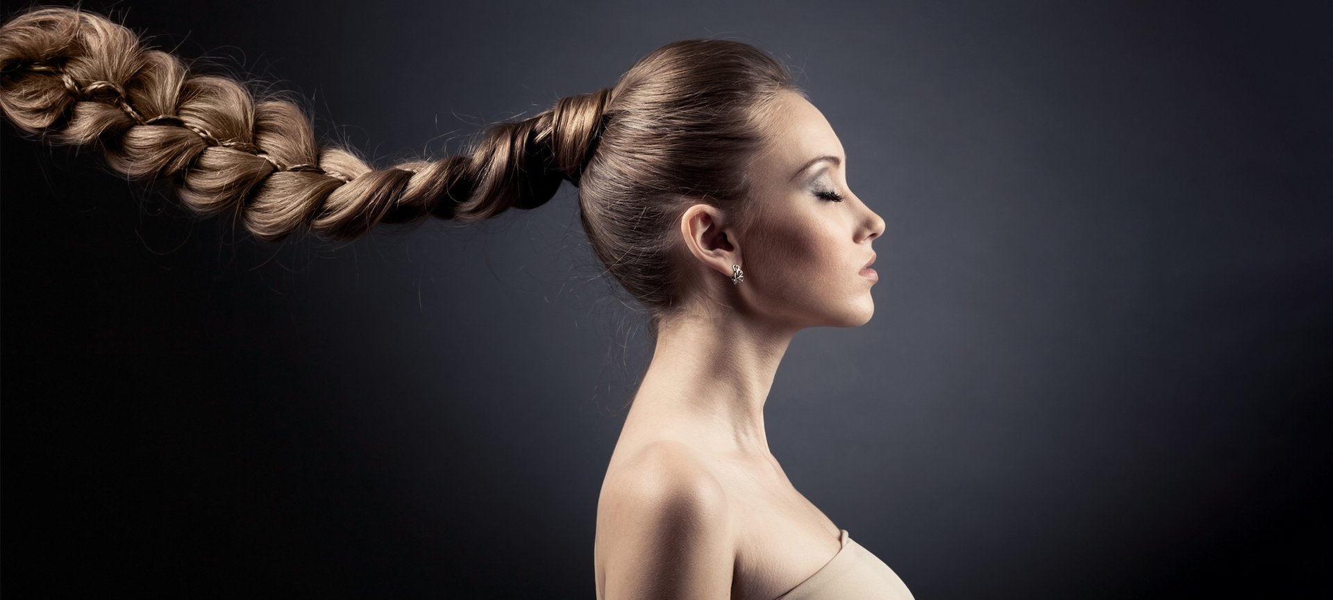 Junge Frau mit langen dunkelblonden geflochtenen Haaren - Profilansicht