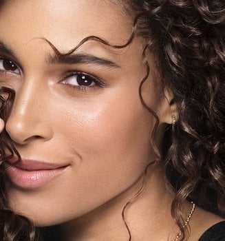 Banner mit Cindy Bruna, die ihr voluminöses, lockiges Haar trägt.