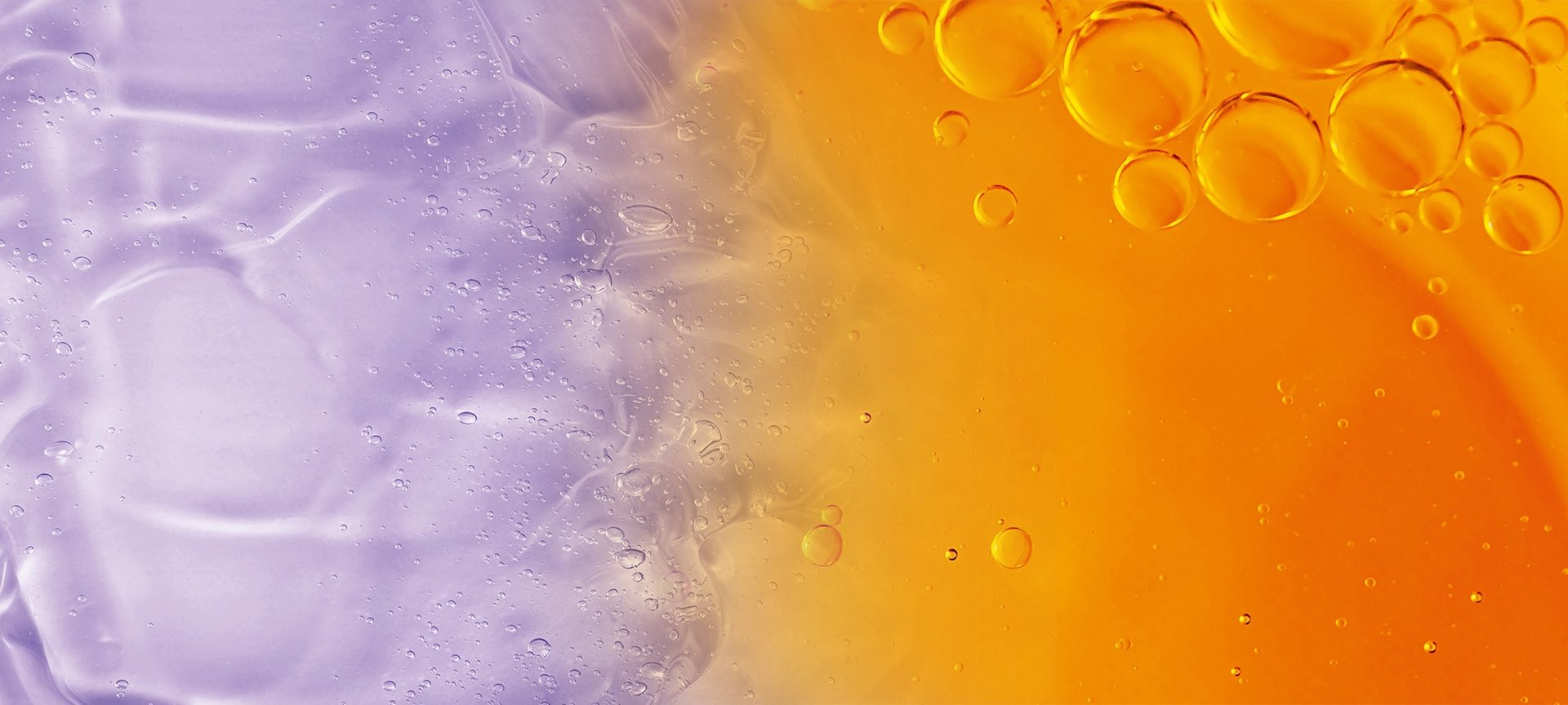 Flüssigkeitstropfen vor violettem und orangenem Hintergrund