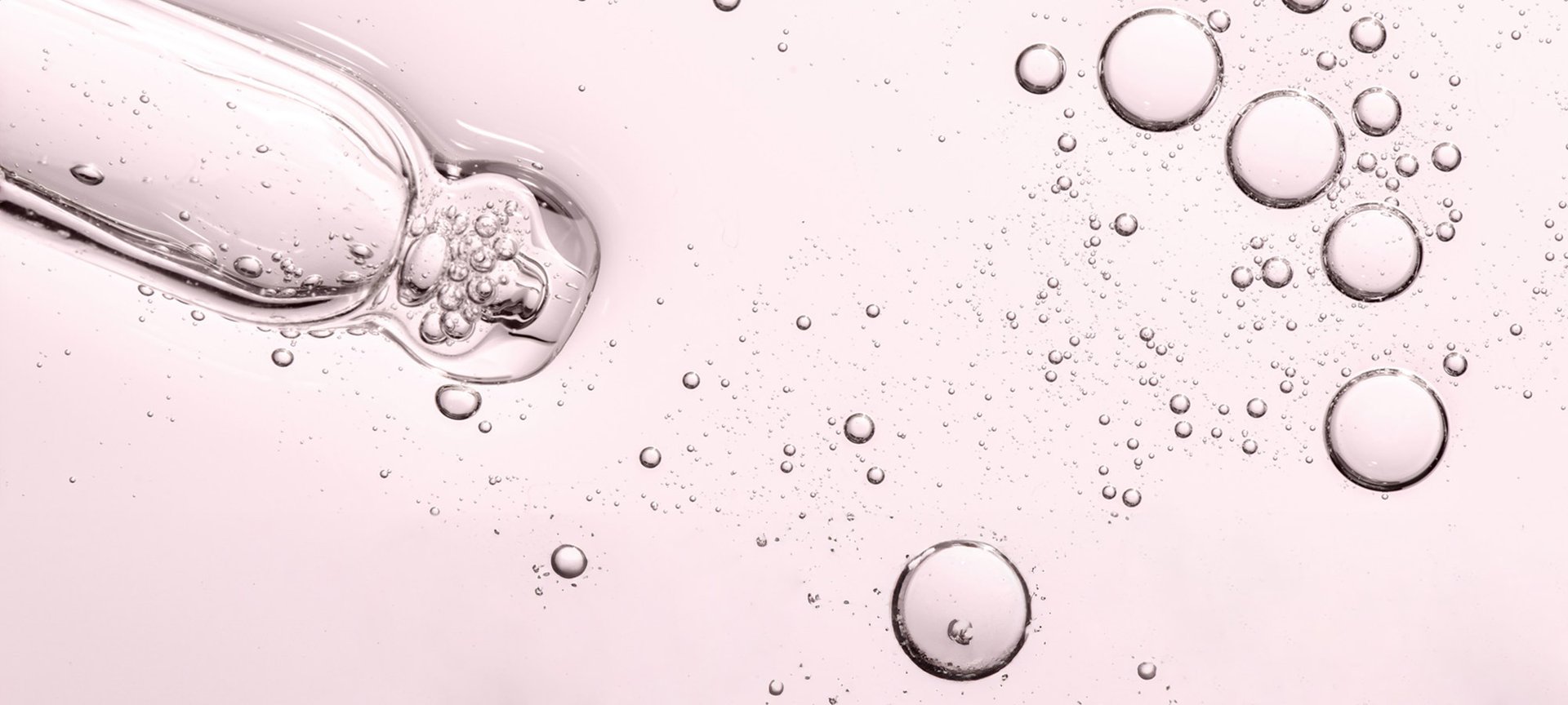 Detailaufnahme einer transparenten rosa Flüssigkeit mit einigen Luftblasen