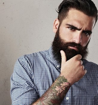 Dunkelhaariger Mann mit langem Hipster-Bart schaut nachdenklich