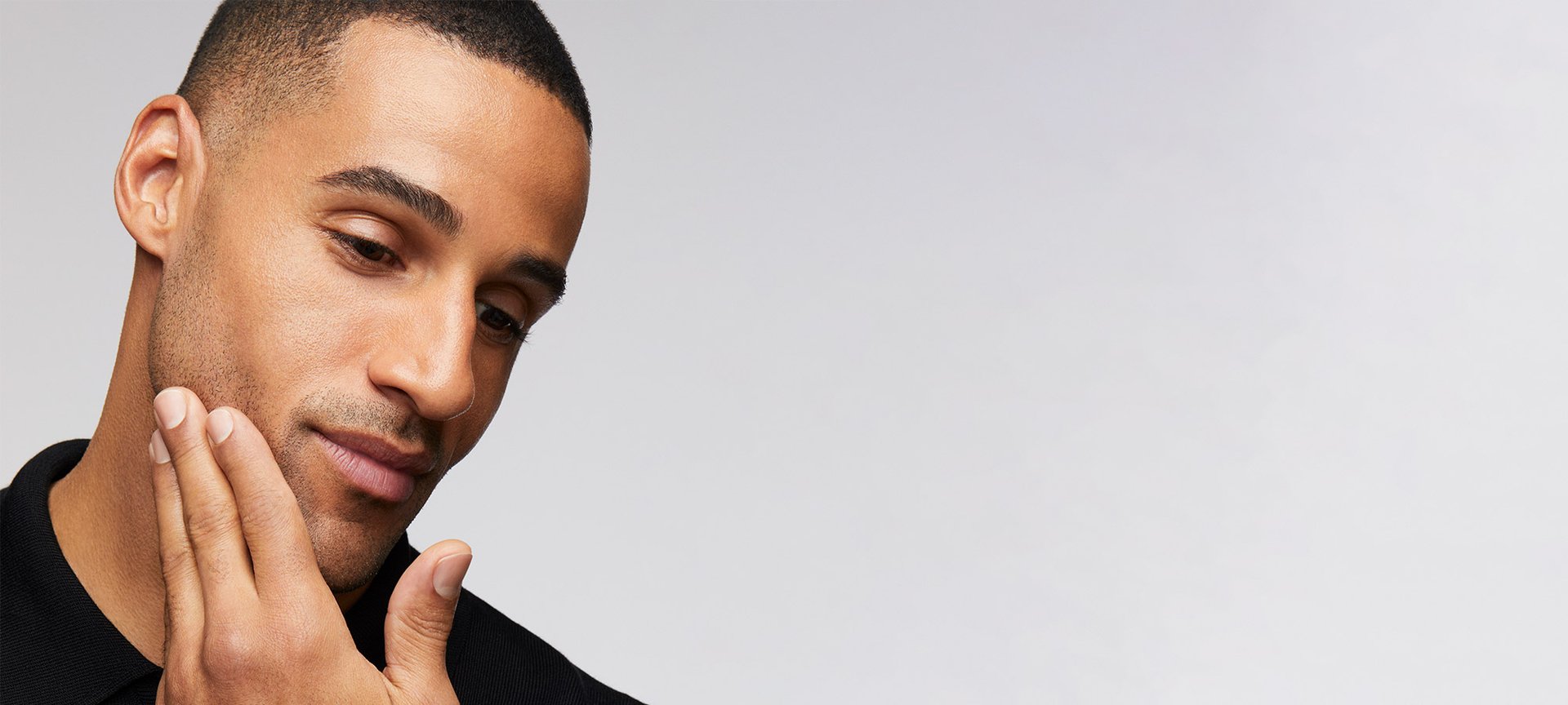 Ein Mann fährt sich mit seiner Hand über seine Wange