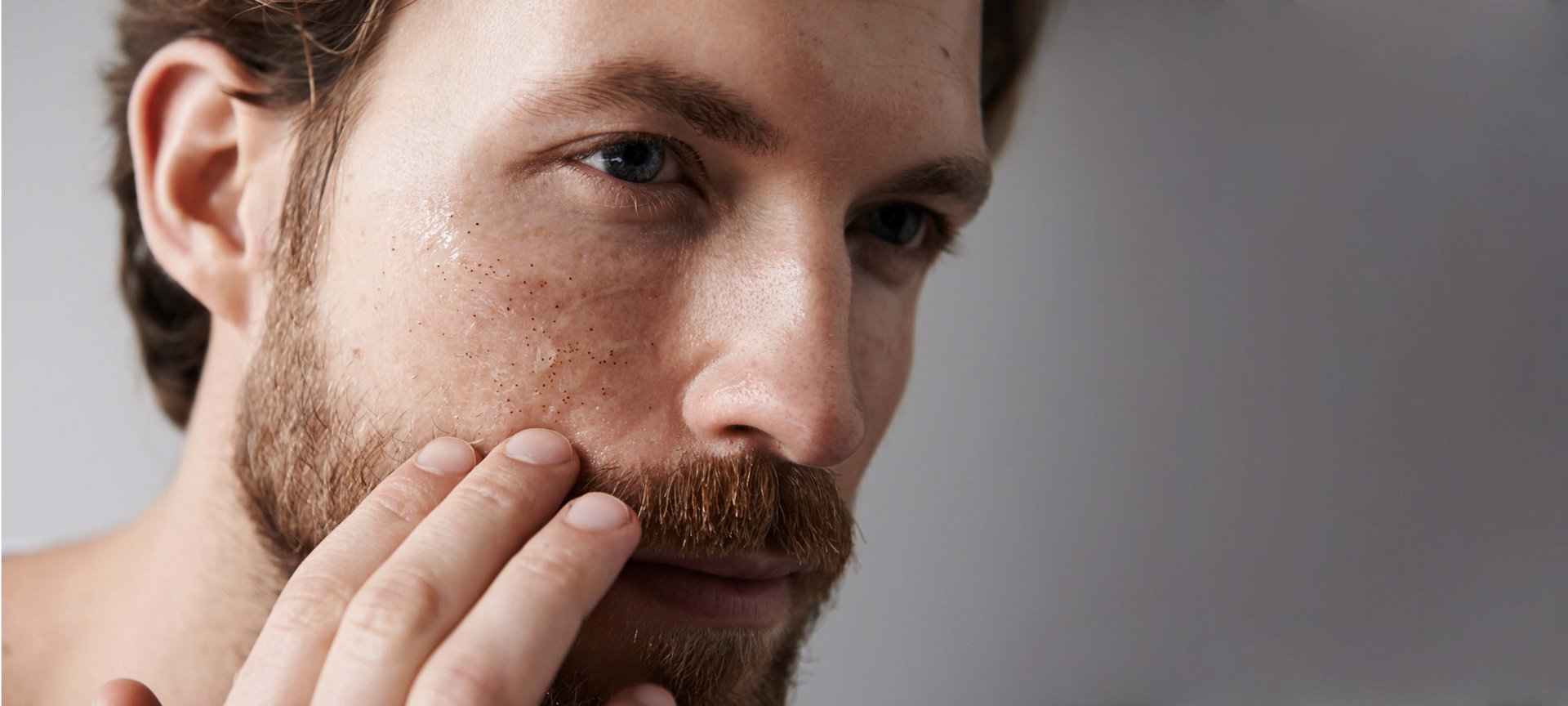 Mann betrachtet sein Gesicht