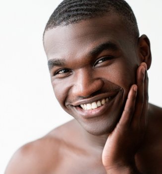 Lächelnder, junger Mann mit einem gepflegten Gesicht