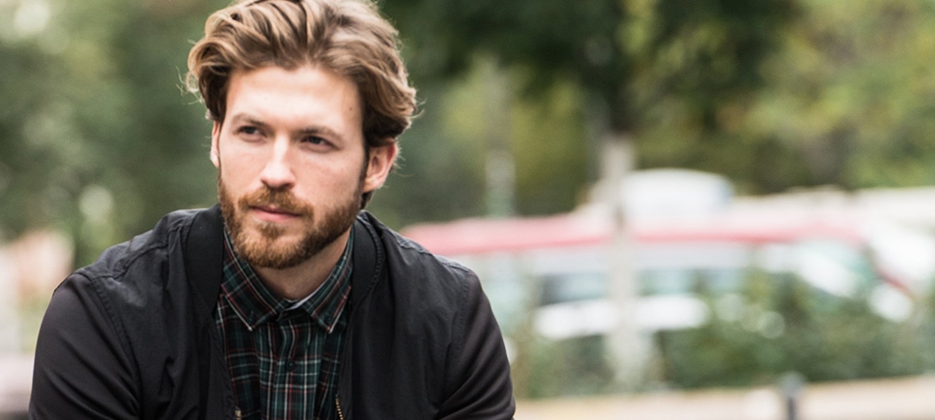 Mann mit Bart in kariertem Hemd und schwarzer Jacke