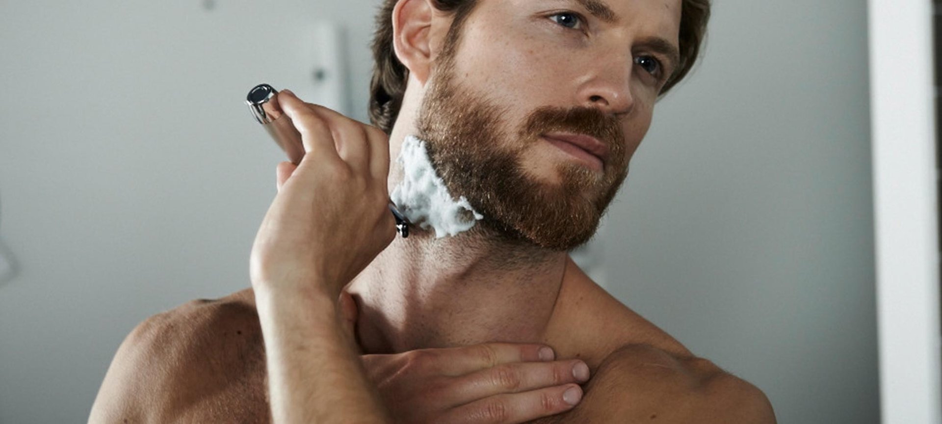 Mann rasiert sich