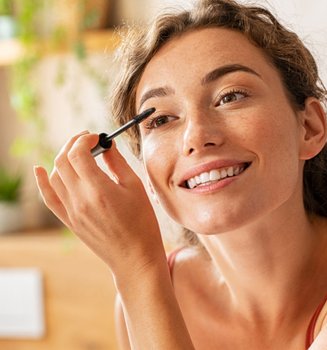Eine junge Frau trägt Make-up auf ihre Augenbrauen auf
