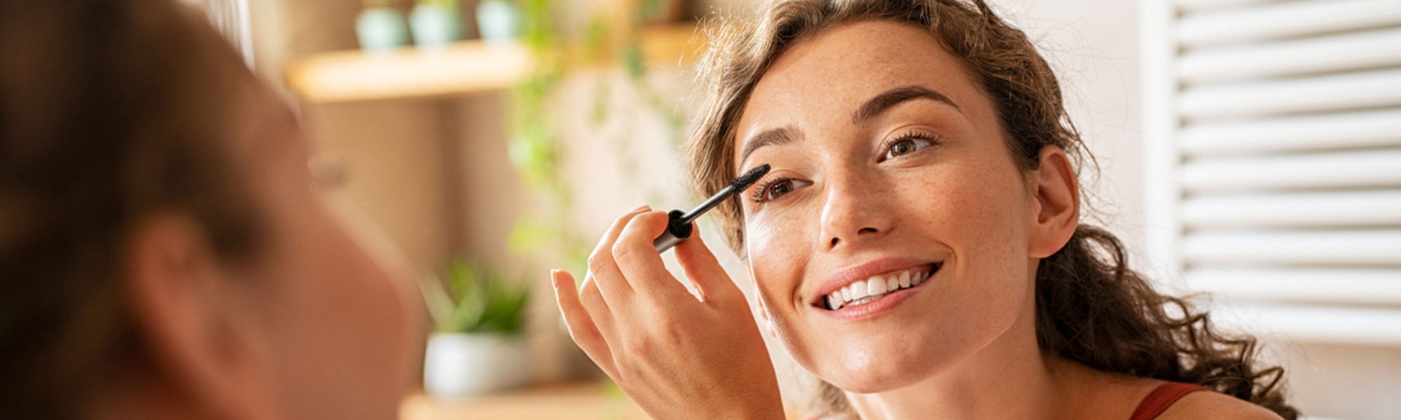Eine junge Frau trägt Make-up auf ihre Augenbrauen auf
