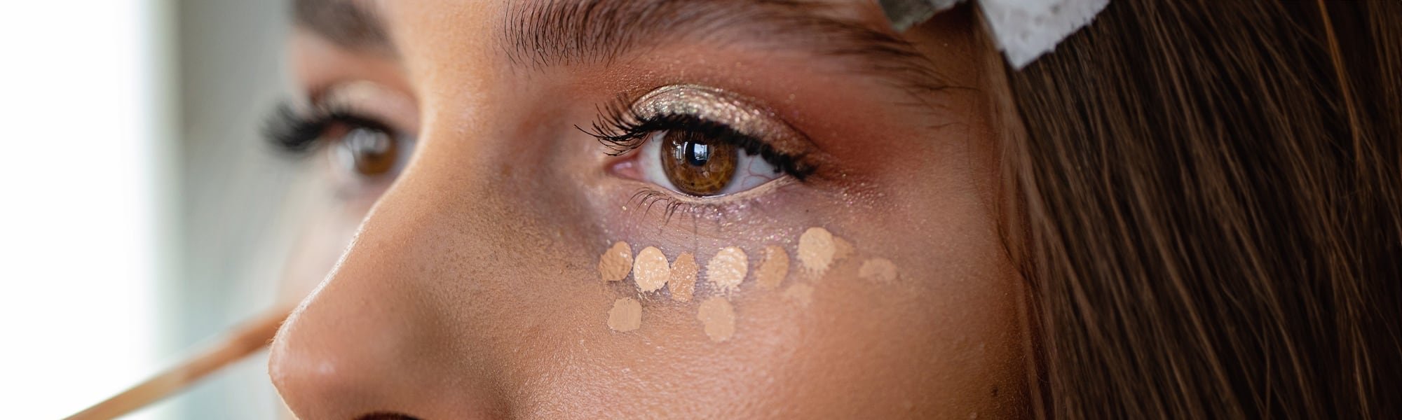 Frau tupft Concealer unter ihre Augen