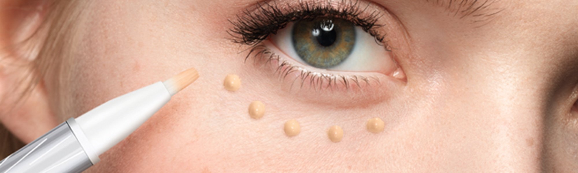 Frau trägt sich Concealer auf