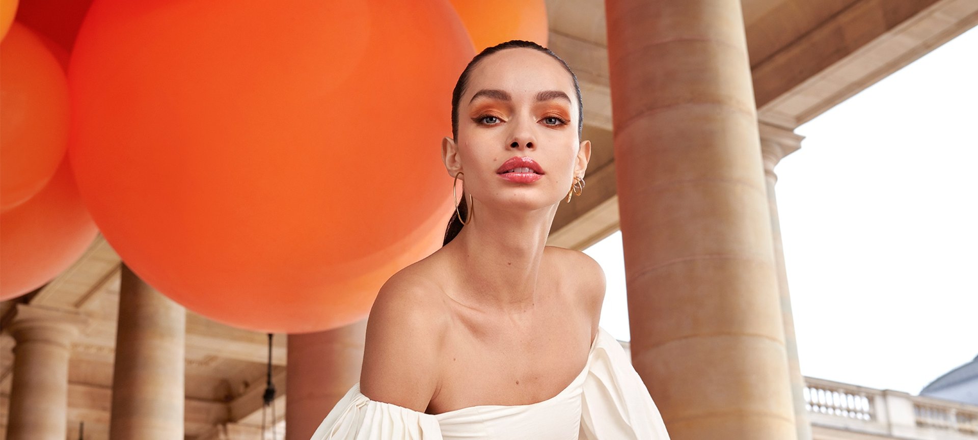 Eine Junge Frau mit zurückgebundenen Haaren und sommerlichem Make-up