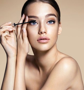 Eine Frau tuscht ihre Wimpern mit Mascara