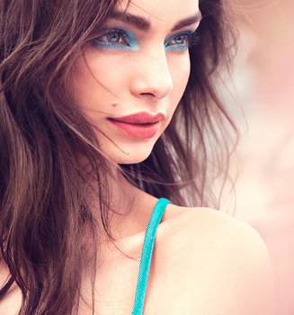 Junge Frau mit Rouge auf ihren Wangen und türkisfarbenen Augen Make-up