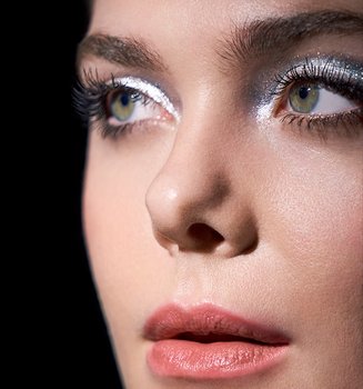 Eine junge Frau mit Smokey Eyes Make-up vor schwarzem Hintergrund