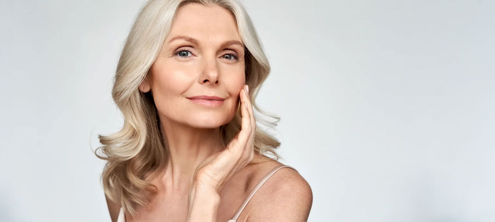 Frau um die fünfzig mustert ihr Gesicht