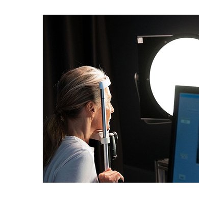 Vor einem Computer wird ein digitaler Gesichtsabdruck einer Frau angefertigt