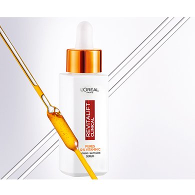 Revitalift Clinical Vitamin C Serum und im Vordergrund ein Glasstäbchen mit gelber Flüssigkeit
