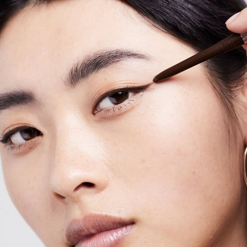 Eine junge Frau trägt einen schwarzen Eyeliner auf