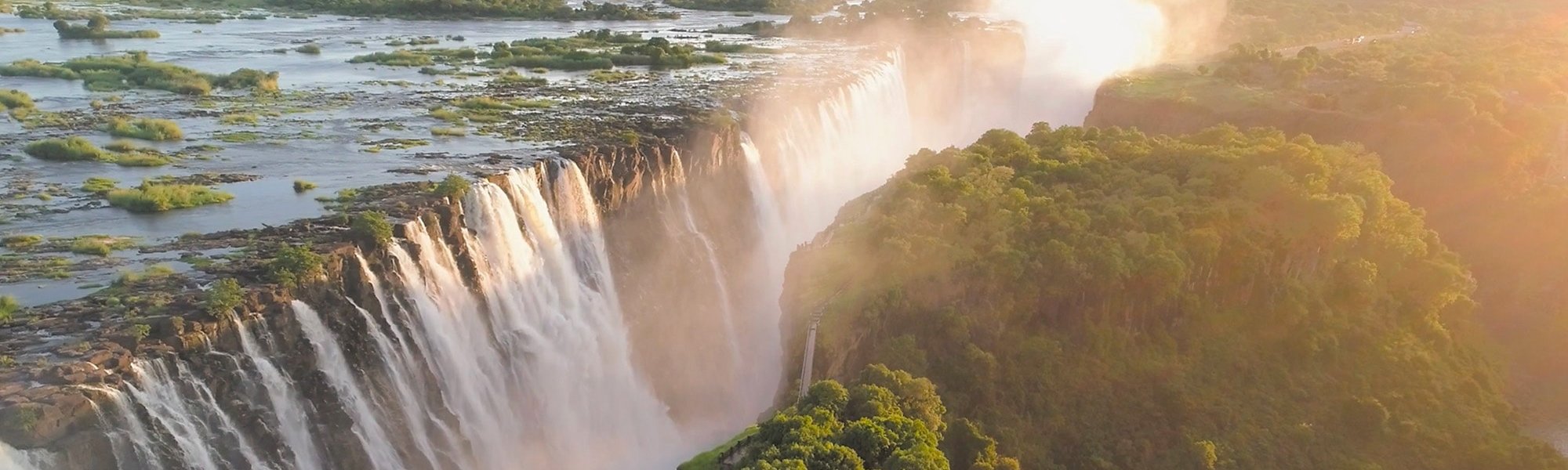 Wasserfall am Rand eines bewaldeten Berges