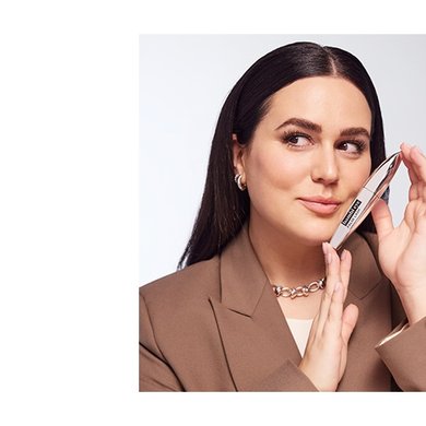 Frau hält False Lash Bambi Eye Mascara in der Hand