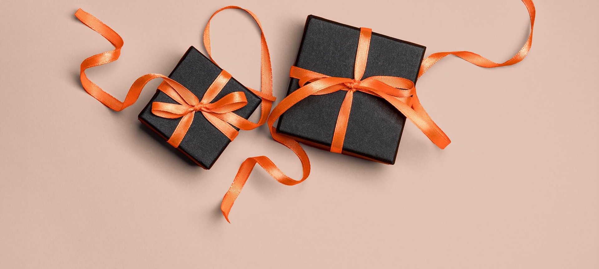 Schwarze Geschenkboxen mit orangenen Schleifen