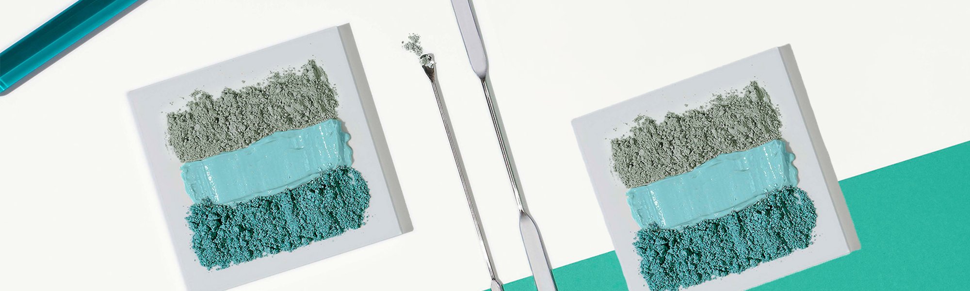 Verschiedenfarbige Tonerden ordentlich nebeneinander gereiht, daneben zwei Laborspachtel