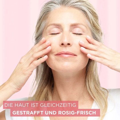 Frau trägt Creme auf ihre Wangen auf