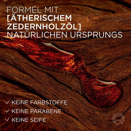 Eine zähflüssige, goldbraune Ölschicht auf einer dunklen Holzrinde symbolisiert das ätherische Zedernholzöl natürlichen Ursprungs. Text im Bild verweist auf die Formel ohne Farbstoffe, Parabene und Seife.