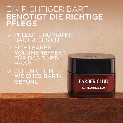 Ein brauner Tiegel des L'Oréal Men Expert Barber Club 3in1 Bartbalsams steht auf einem Holzuntergrund. Daneben sind die Produktvorteile aufgelistet: pflegt und nährt Bart & Gesicht, sichtbarer Volumeneffekt, schenkt ein weiches Bartgefühl.