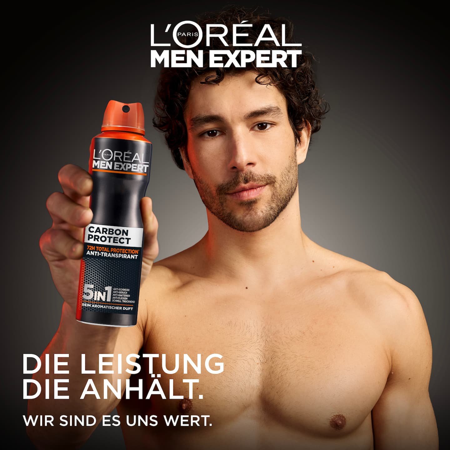 Ein Mann hält die Carbon Protect Deospray-Dose vor dunklem Hintergrund.