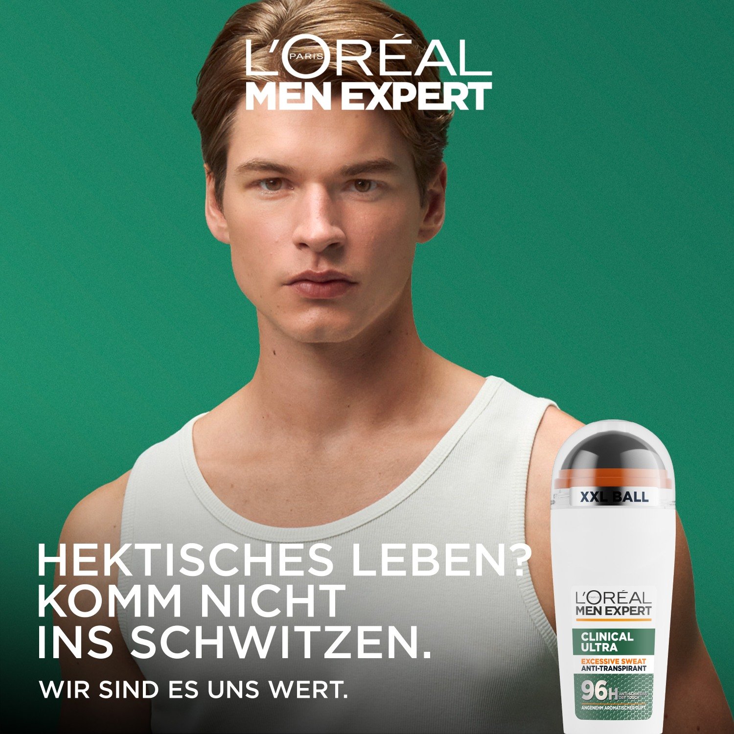 Junger Mann im weißen Unterhemd vor grünem Hintergrund hält L'Oréal Men Expert Clinical Ultra Deoroller, Werbetext Hektisches Leben Komm nicht ins Schwitzen