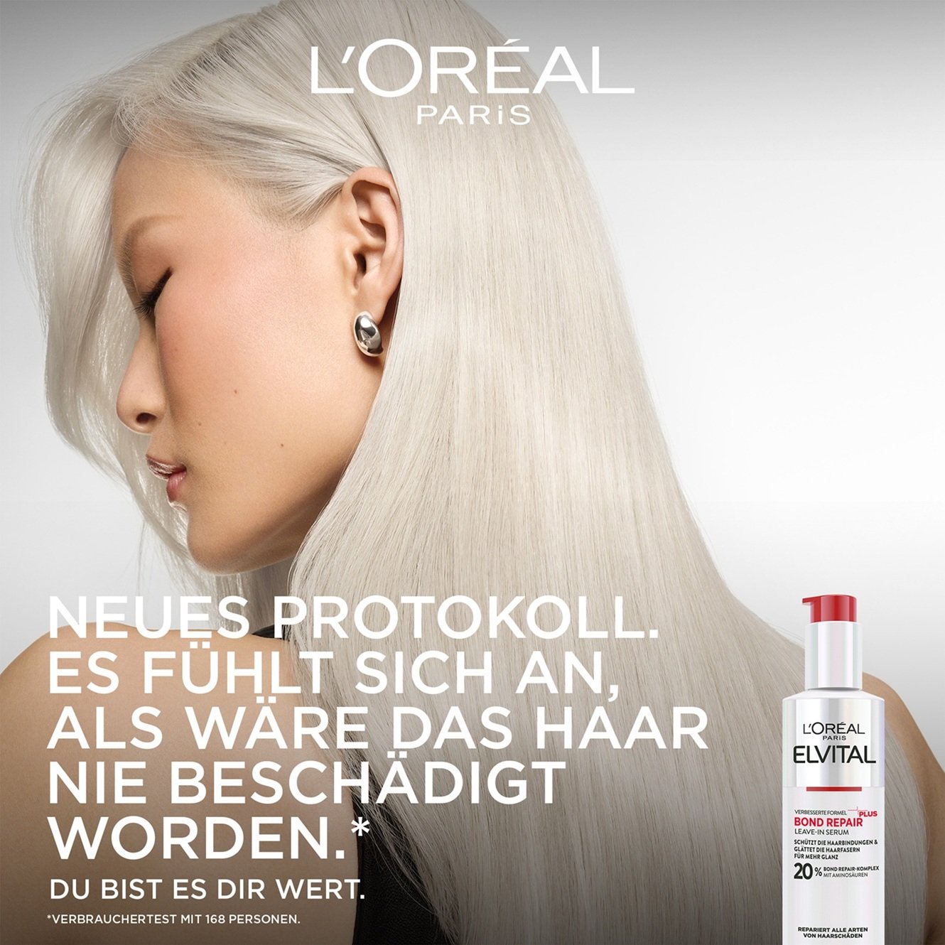 Werbebild mit dem Profil einer Frau mit seidigem, platinblondem Haar auf der linken Seite. Rechts unten steht die Flasche des Bond Repair Leave-In Serums. Der Slogan lautet: „NEUES PROTOKOLL. ES FÜHLT SICH AN, ALS WÄRE DAS HAAR NIE BESCHÄDIGT WORDEN.* DU BIST ES DIR WERT.“ mit der Fußnote „*Verbrauchertest mit 168 Personen“.