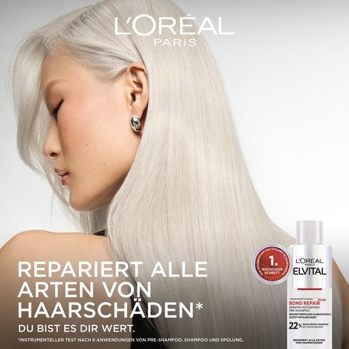 Werbebild mit dem Profil einer Frau mit seidigem, platinblondem Haar auf der linken Seite. Rechts unten steht die Flasche des „Bond Repair Pre-Shampoos“ mit einem roten Siegel daneben, das es als „1. Wichtigsten Schritt zur Regeneration“ kennzeichnet. Der Slogan lautet: „REPARIERT ALLE ARTEN VON HAARSCHÄDEN* DU BIST ES DIR WERT.“ mit der Fußnote zu instrumentellen Tests nach 6 Anwendungen.