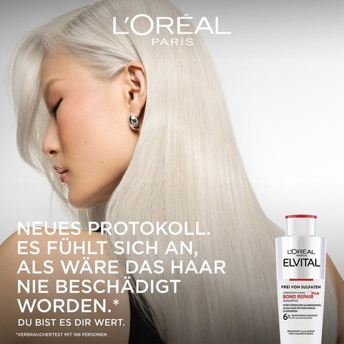 Werbebild für L'Oréal Paris Elvital Bond Repair. Links zeigt sich das Profil einer Frau mit seidigem, platinblondem Haar, rechts steht die Shampooflasche. Der Slogan lautet: „NEUES PROTOKOLL. ES FÜHLT SICH AN, ALS WÄRE DAS HAAR NIE BESCHÄDIGT WORDEN.* DU BIST ES DIR WERT.“ mit der Fußnote „*Verbrauchertest mit 168 Personen“. Auf der Flasche steht: „L'Oréal Paris Elvital Bond Repair Shampoo, 6% Bond Repair-Komplex mit Aminosäuren, repariert alle Arten von Haarschäden.“