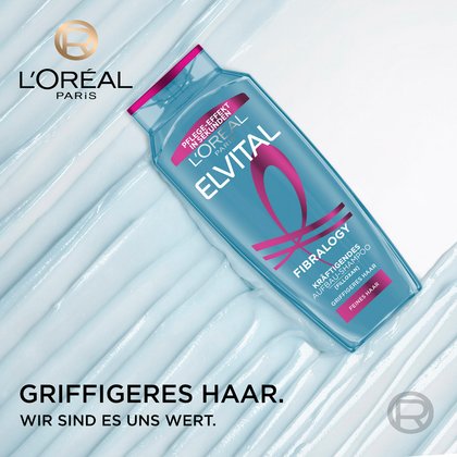 Schräg liegende Elvital Fibralogy Shampoo-Flasche auf einer hellblauen Gel-Textur mit dem L'Oréal Paris Logo und dem Slogan „Griffigeres Haar. Wir sind es uns wert.“.