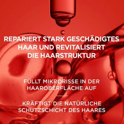 Rote Pipette und Öltropfen in Nahaufnahme vor rotem Hintergrund mit dem Text: „Repariert stark geschädigtes Haar, füllt Mikrorisse in der Haaroberfläche auf und kräftigt die natürliche Schutzschicht des Haares.“