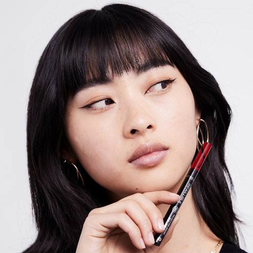 Junge Frau hält Eyeliner Infaillible 36h Grip Micro-Fine Liner 01 Obsidian in der Hand