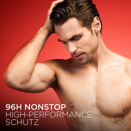 Ein Mann berührt sein feuchtes Haar vor rotem Hintergrund.