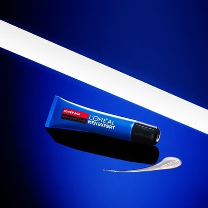 L'Oréal Men Expert Power Age Feuchtigkeitscreme in blauer Tube auf blauem Hintergrund mit sichtbarer Textur-Probe.