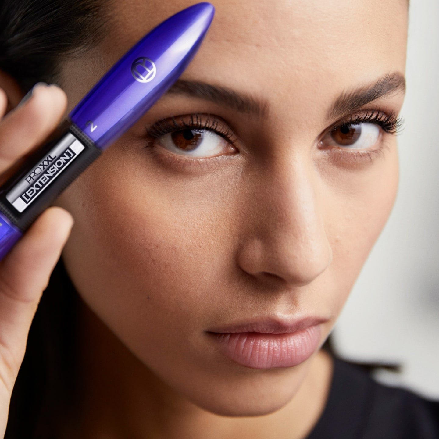 Brünette Frau präsentiert ProXXL Extension Mascara
