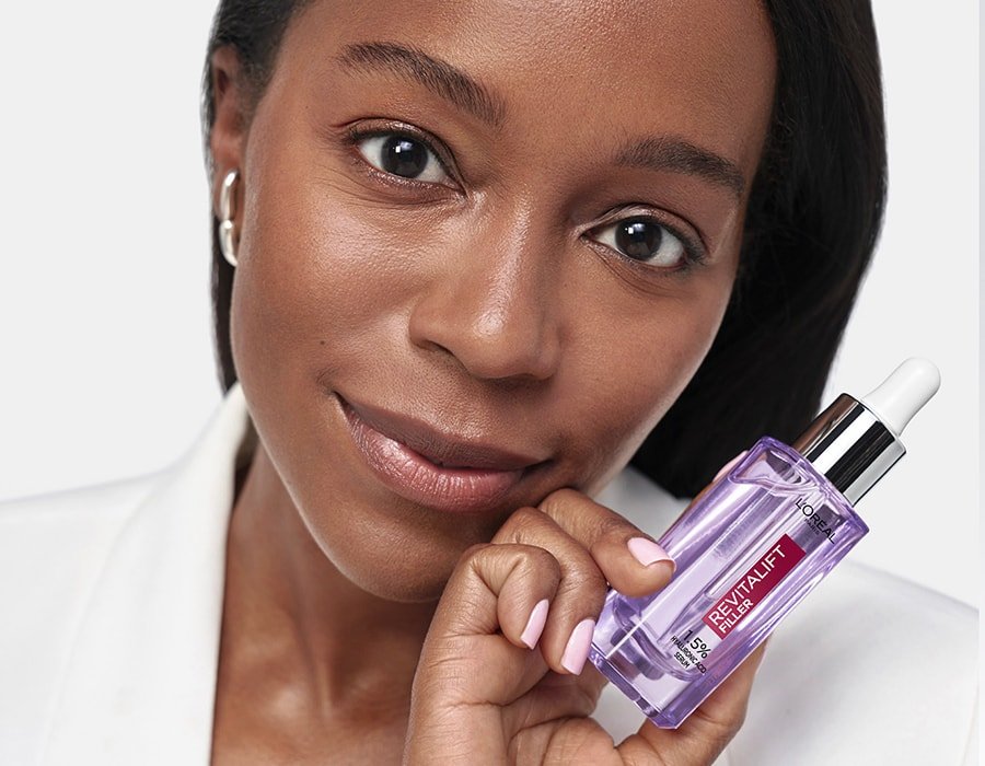 Eine junge Frau hält das Revitalift Filler Anti Falten Serum 30ml in ihrer Hand